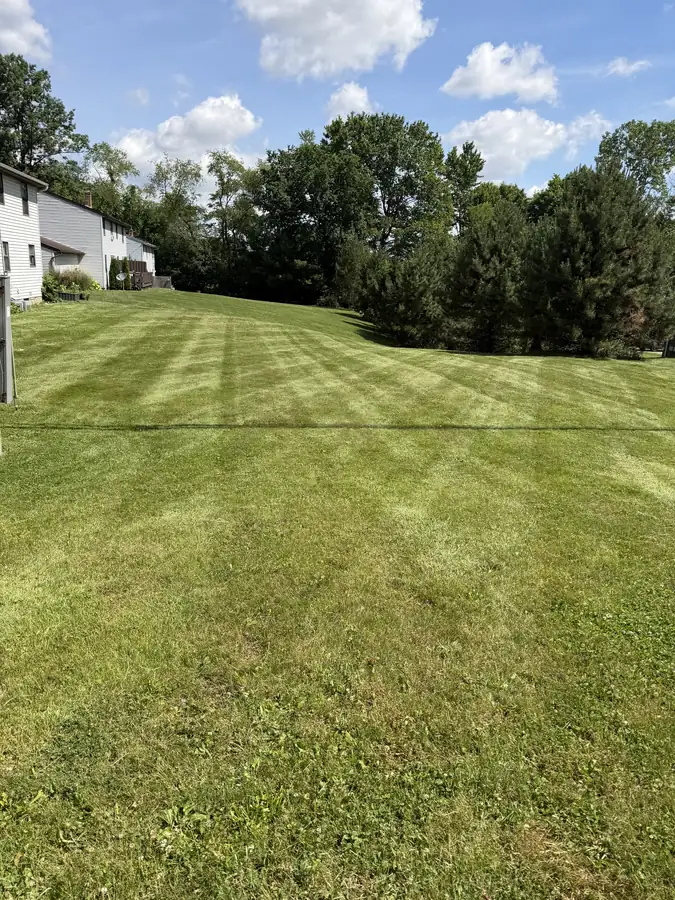 Rolling hillside lawn mowed with sharp stripes